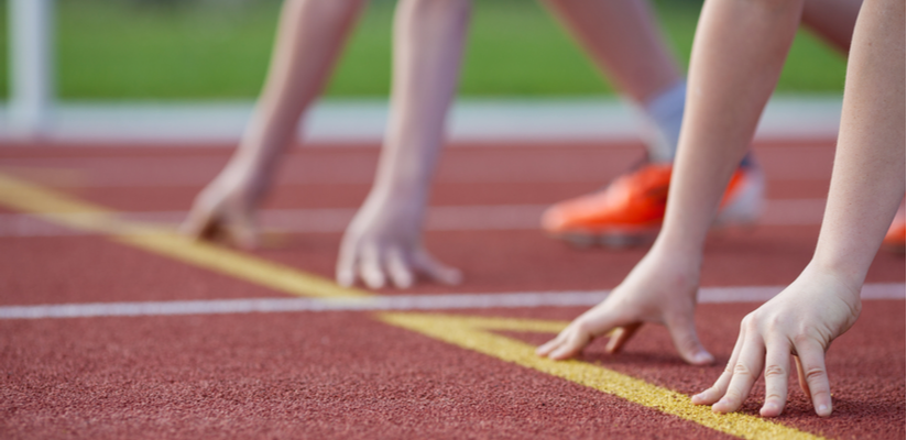 Kids lining up at the start line on an athletics track