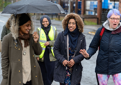 Group of smiling women on a walk in a suburban area