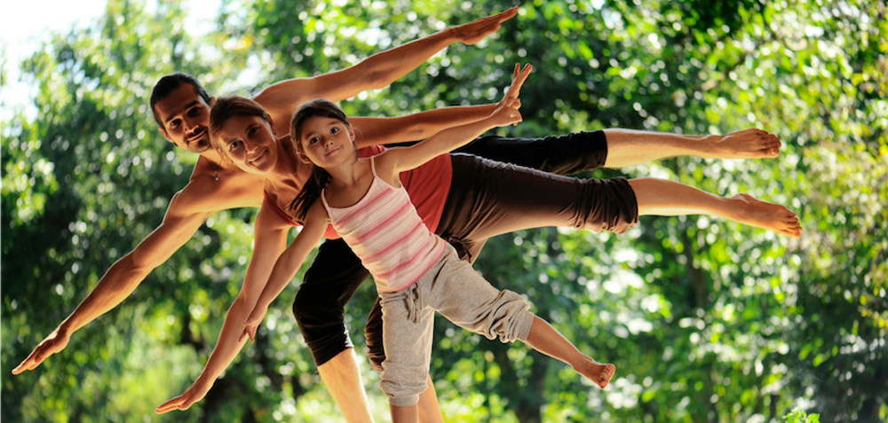 Man, woman and child all balancing on one leg