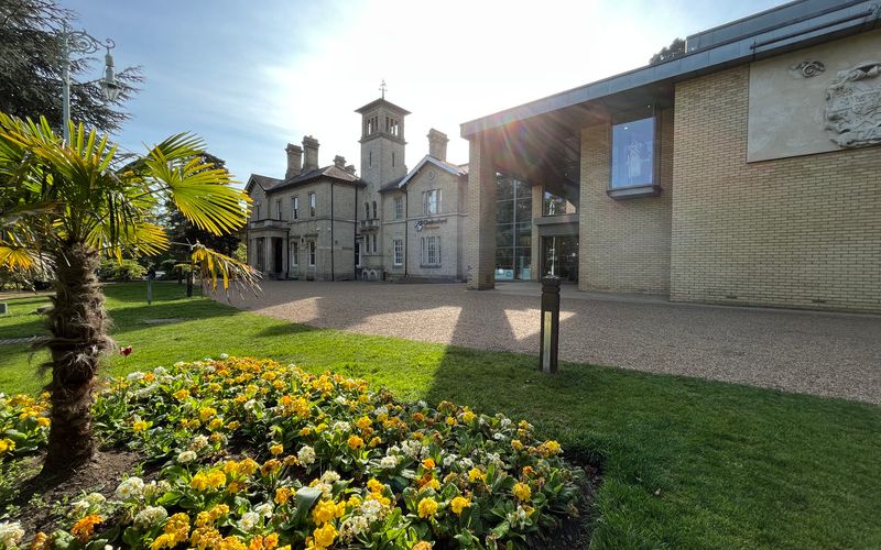 Outside Chelmsford Museum on a sunny day with a patch of flowers in the foreground. 