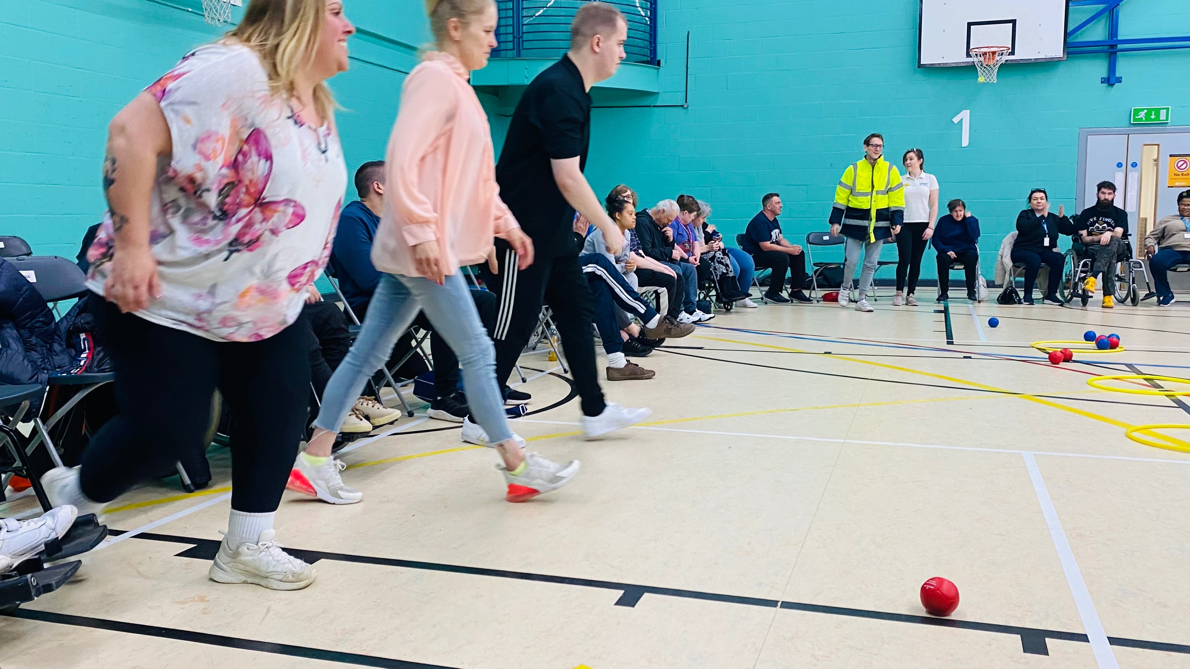 A group of people walking towards boccia balls