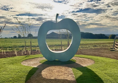 Large art installation in the shape of an apple, with hole in the middle for seating (photo credit: Julie Edwards)
