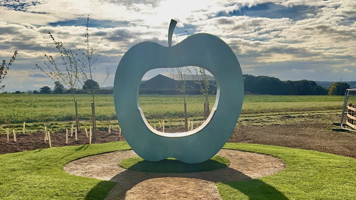 Large art installation in the shape of an apple, with hole in the middle for seating (photo credit: Julie Edwards)