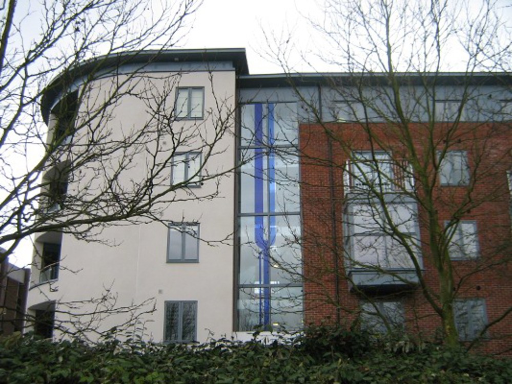 Blue glass panels depicting stylized river in window of block of flats