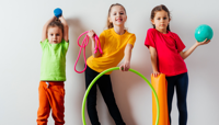 Three young children with play equipment, including hoops, ropes and balls preview