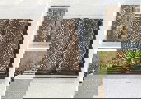 Bronze statue of book on a plinth, engraved with 'But now this park where deer would graze and roam'