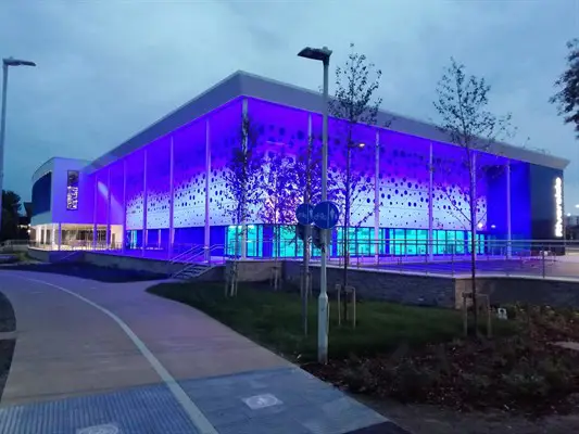 Riverside Leisure Centre lit up blue at dusk