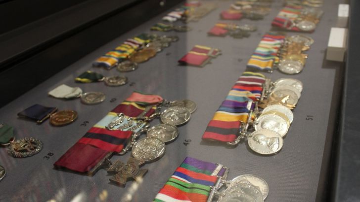 A close up of a case display with medals. 