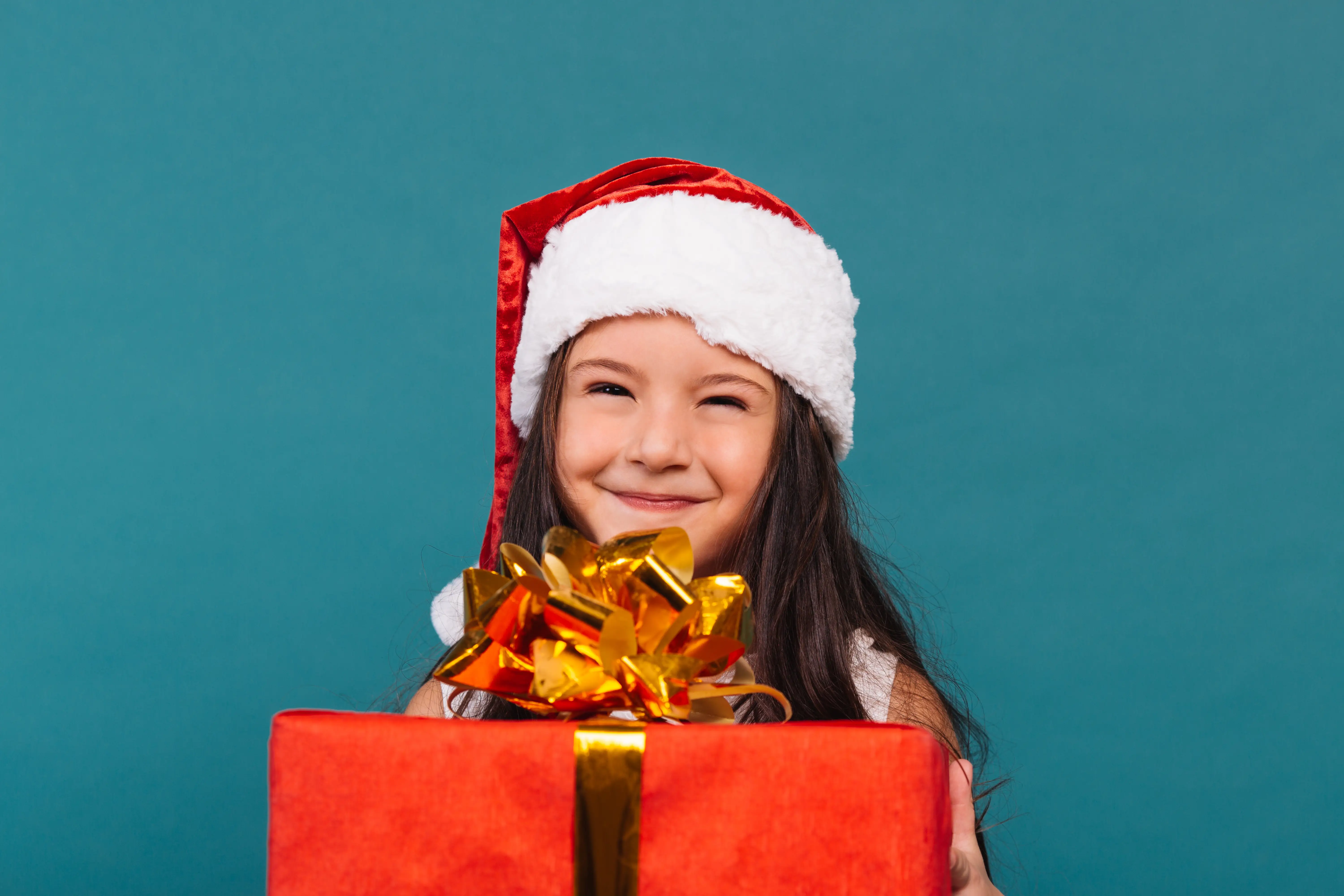 Young Girl In Christmas Hat Holding A Present