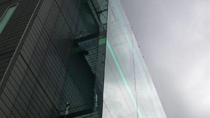 Top of a tall building with glass down the side