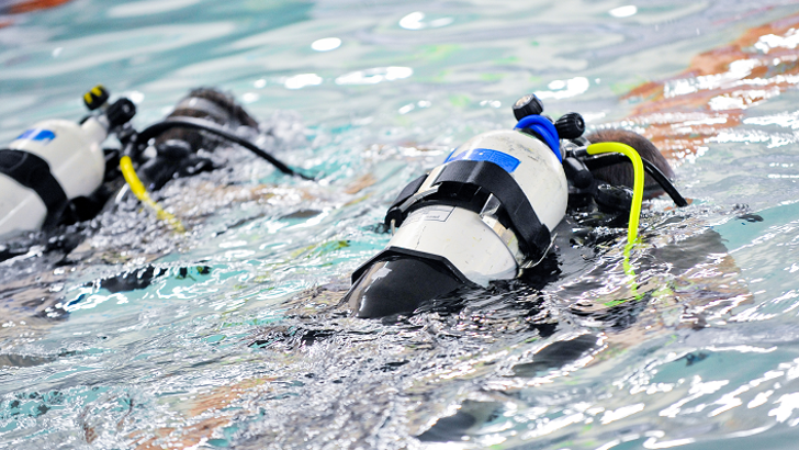 Scuba divers underwater in swimming pool