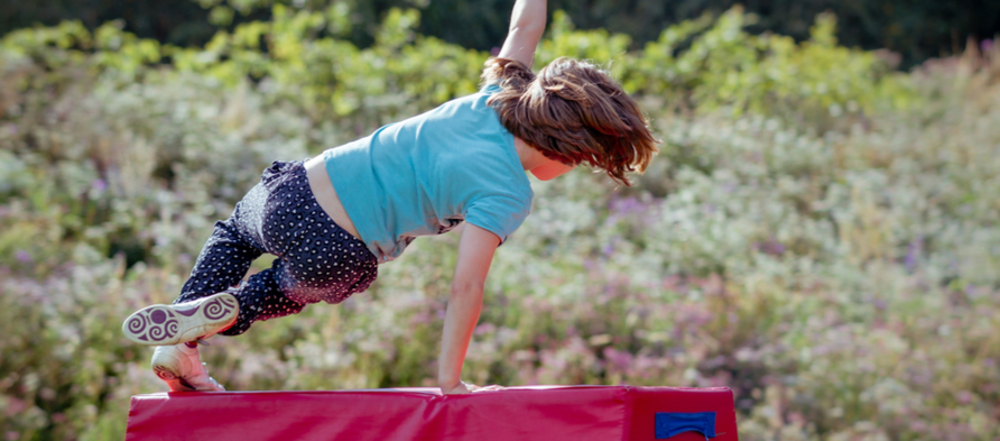 Child leaping over obstacle