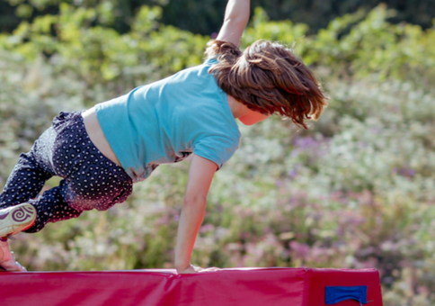 Child leaping over obstacle