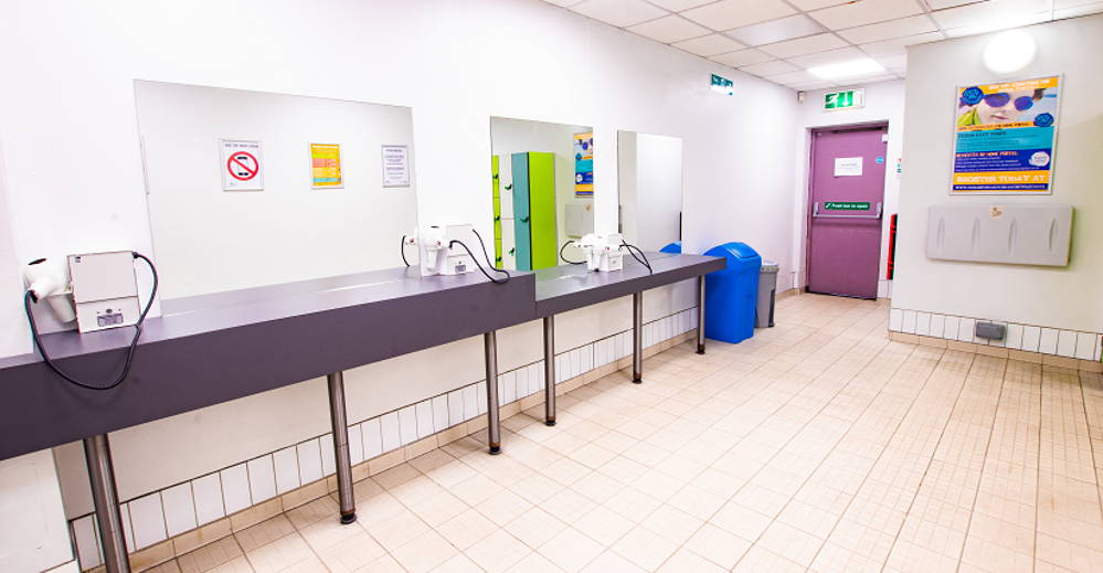 Changing rooms with open area with long counter in front of mirrors