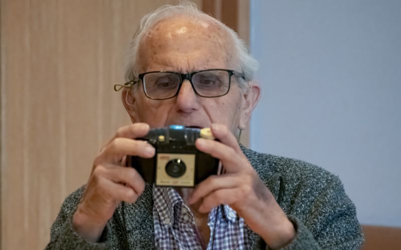 A man looking at a vintage camera.  preview