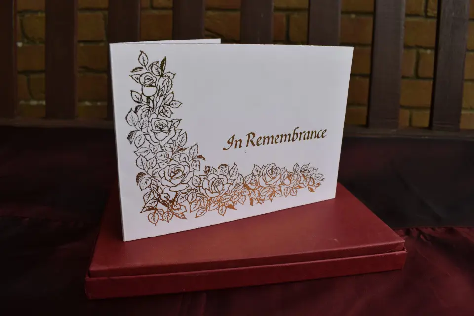 White card with gold decoration and 'In Remembrance' lettering