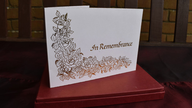 White card with gold decoration and 'In Remembrance' lettering