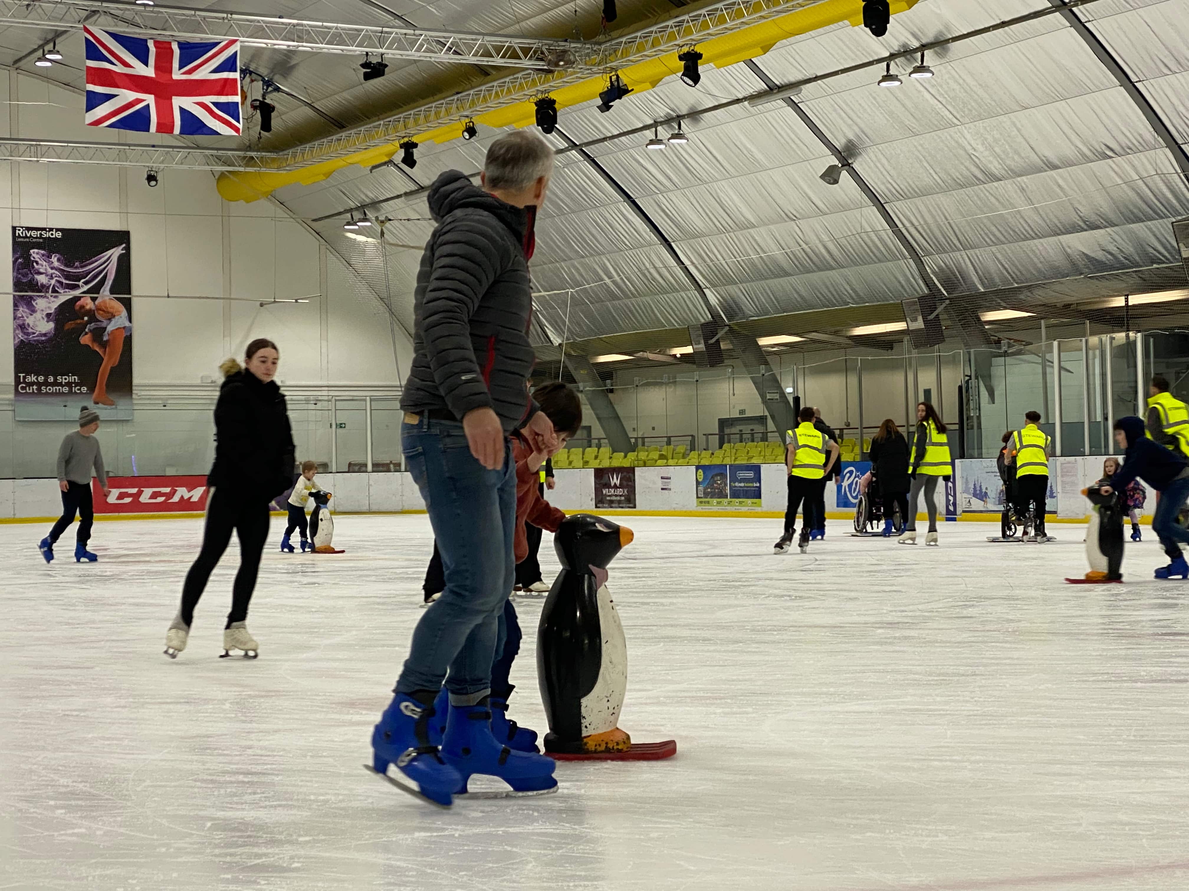 Father and daughter holding hands ice skating