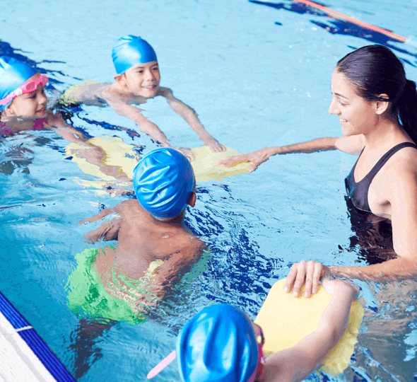 Woman in pool teaching children to swim